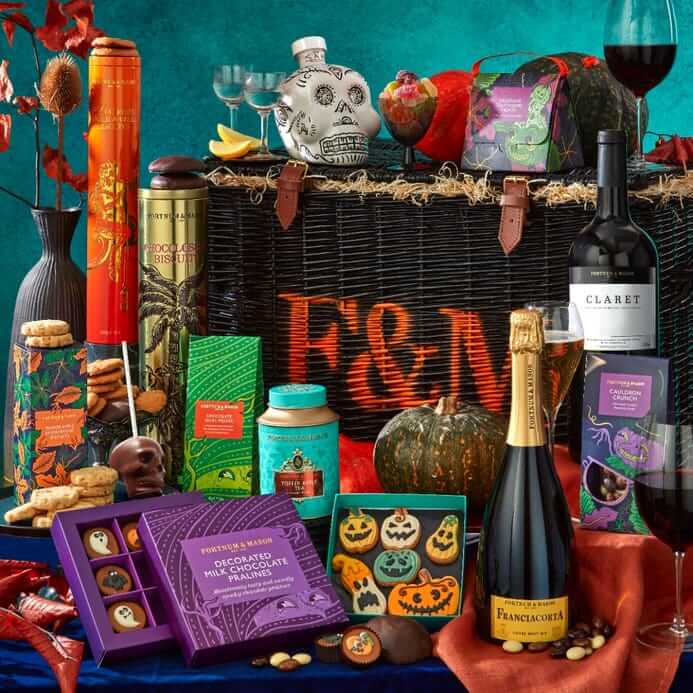 An array of Halloween themed treats surround an F&M hamper, including sparkling wine, ghost chocolates, wines, chocolates